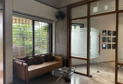 Casual waiting area with a wooden sofa and glass partition walls.