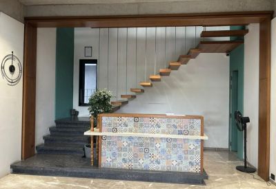 Reception area with a patterned front desk and a unique floating staircase.