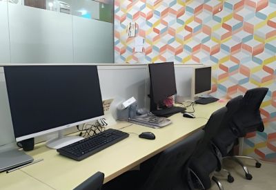 Coworking space featuring modern workstations and a colorful geometric patterned wall.