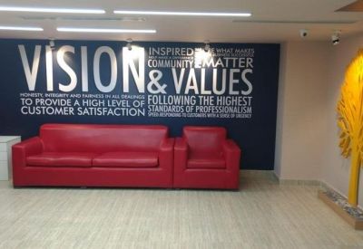 Reception area featuring a red sofa and large Vision and Values wall branding.