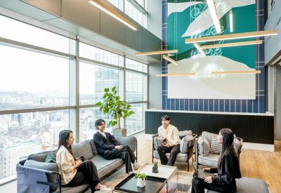 Spacious communal lounge with floor-to-ceiling windows, modern seating, and abstract wall art.
