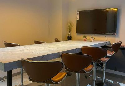 Spacious boardroom with a large marble table, leather chairs, and pendant lighting.