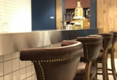 Sophisticated bar-style seating with leather chairs and warm lighting in a communal area.