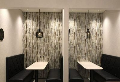 Private booths for focus work featuring black leather benches and textured feature walls.