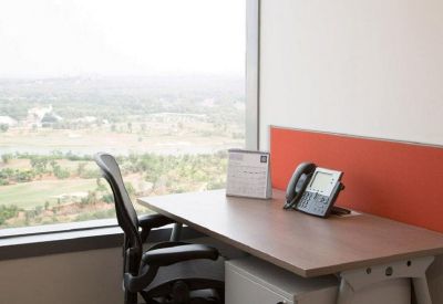 Private office workstation with a desk phone and large window overlooking the city landscape.