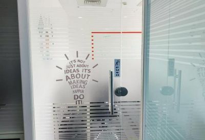 Glass office door with an inspirational lightbulb graphic and frosted privacy stripes.