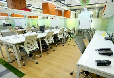 Open-plan workspace with long desks and office chairs.