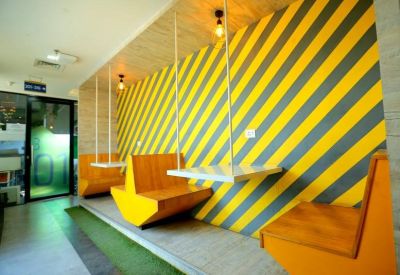 Indoor seating area with bold yellow and gray striped walls.