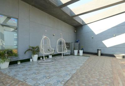Rooftop area with hanging chairs and potted plants.