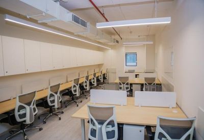 Bright open-plan office space with rows of ergonomic chairs and white storage cabinets.