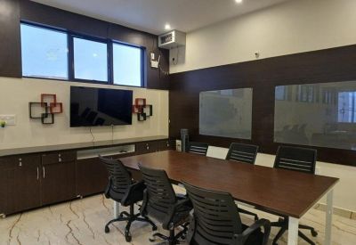 Professional meeting room with a dark wood table, black chairs, and a wall-mounted TV.