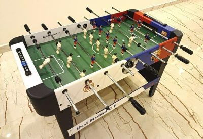 Tabletop foosball game in a brightly lit recreation or breakout area.