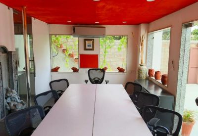 Meeting room with a white conference table, mesh chairs, and a bold red ceiling.