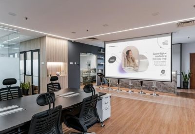 Conference room setup with a large projector screen and black mesh chairs.