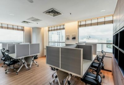 Professional workspace featuring cubicles with grey privacy screens and city views.
