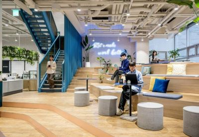 Spacious tiered seating area in a modern lounge with blue stairs and indoor plants.