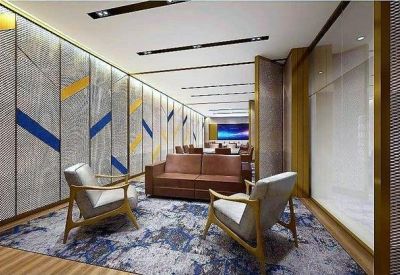 Small meeting room with leather sofa, armchairs, and blue patterned rug.