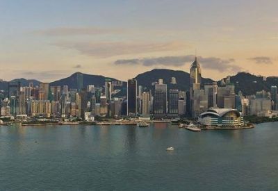 Elevated panoramic view of the Hong Kong skyline across the water at dusk.