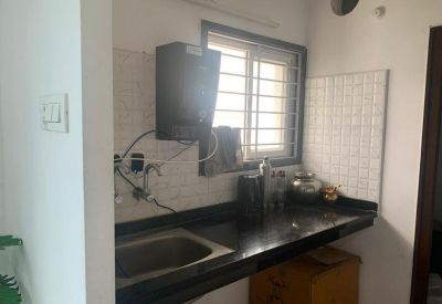 Compact kitchenette area featuring a black countertop, sink, and water filtration system.