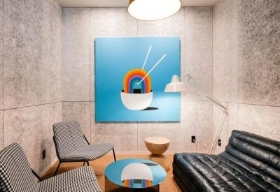 Modern lounge area with a colorful ramen bowl painting on a grey wall.
