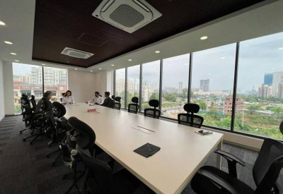 Bright boardroom with a long light-wood table and floor-to-ceiling windows showing city views.