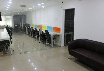 Reception lounge area with a dark leather sofa and glass partition wall.