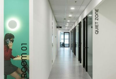 A long white corridor leading to private phone booths and quiet zones.