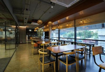 Bright coworking area with wooden tables, modern chairs, and large windows overlooking the city.