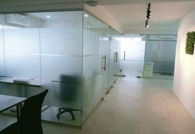 Bright hallway with frosted glass office partitions and a small vertical garden feature.