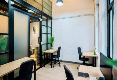 Small meeting area with individual desks separated by black-framed glass partitions.
