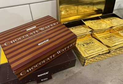 Selection of chocolate wafer boxes and gold tea sachets displayed on a counter.