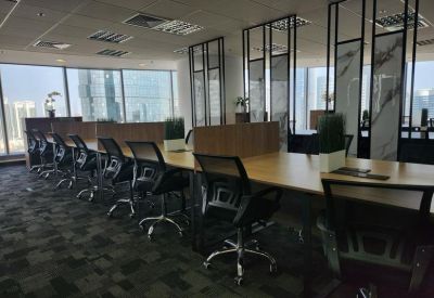 A long communal desk by large windows with panoramic city views.