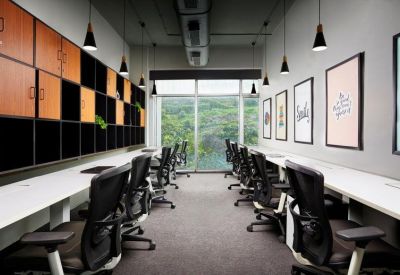 Long white workstations with black ergonomic chairs and wooden cabinet wall.