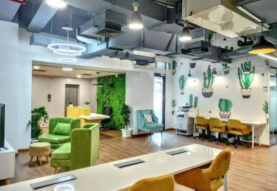 Lounge area with green armchairs and a living moss wall near the reception.