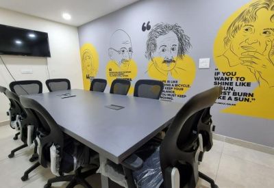 Modern meeting room with portrait sketches of famous figures on a yellow and grey feature wall.