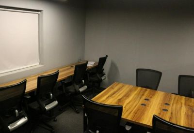 Small private office suite featuring wooden desks and black ergonomic chairs.