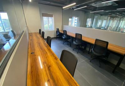 Compact workstation area with wooden desks separated by low white partitions.