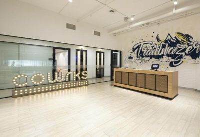Sleek reception area with light-up signage and a wooden front desk.
