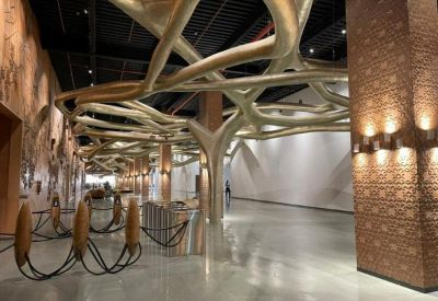 Spacious lobby featuring a unique golden tree-like overhead structure and polished floors.