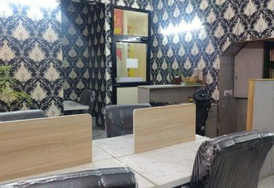 Workstations with light wood dividers against a dark patterned feature wall.