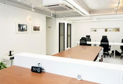 Professional long wooden meeting table in a bright, white-walled room.
