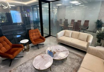 Reception lounge featuring orange velvet armchairs and marble coffee tables.