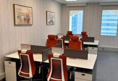 Modern workspace with white desks and ergonomic red chairs.