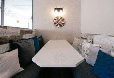 Cozy meeting booth with plush cushions and a white table.
