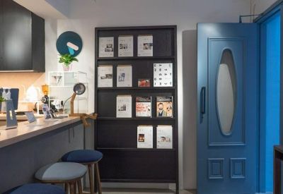 Reception area with a blue door, wooden counter, and magazine display shelf.