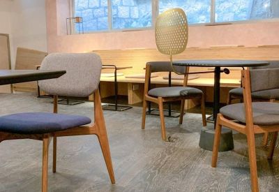 Modern workspace with blue chairs and light wood bench seating along a pink wall.