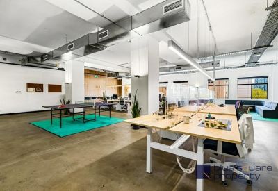 Bright office space featuring a ping pong table on a teal rug.