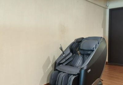 Private corner featuring a black massage chair under an air conditioning unit.