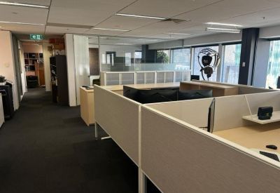 Open-plan workspace with partitioned desks and windows.