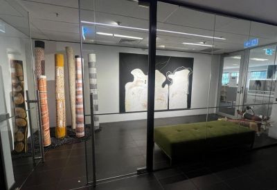 Glass-walled meeting room with abstract art displays.